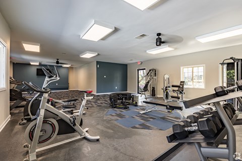 a gym with various machines and weights on the floor